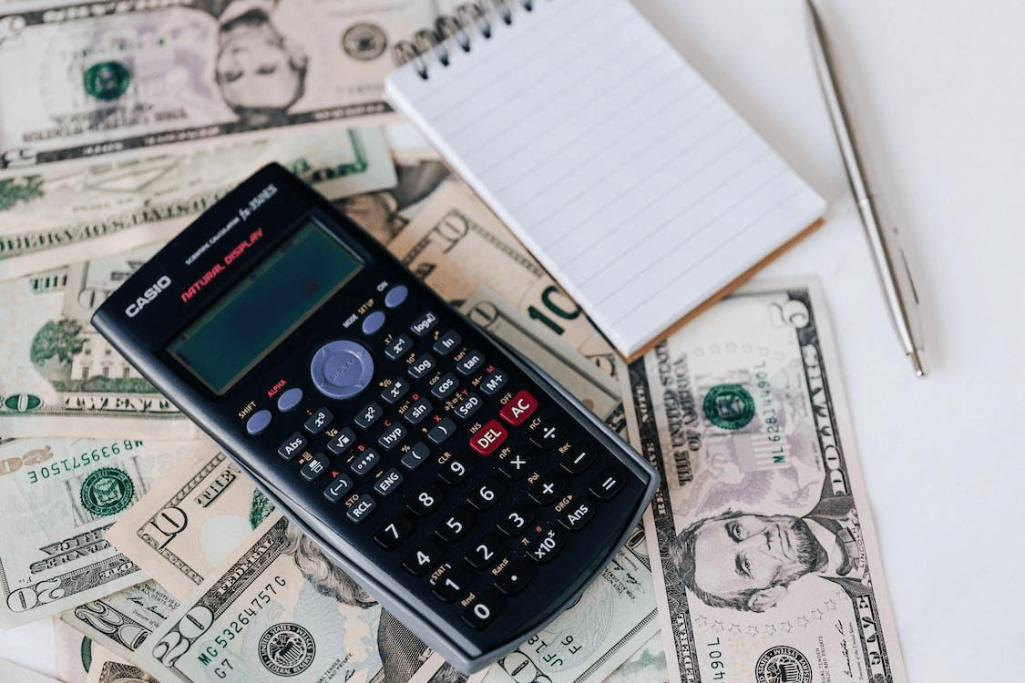 Calculator and Notebook on dollar bills