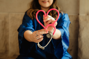 a person creating a heart with a stethoscope.