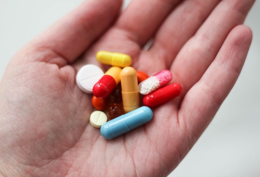 a person holding various medications. 