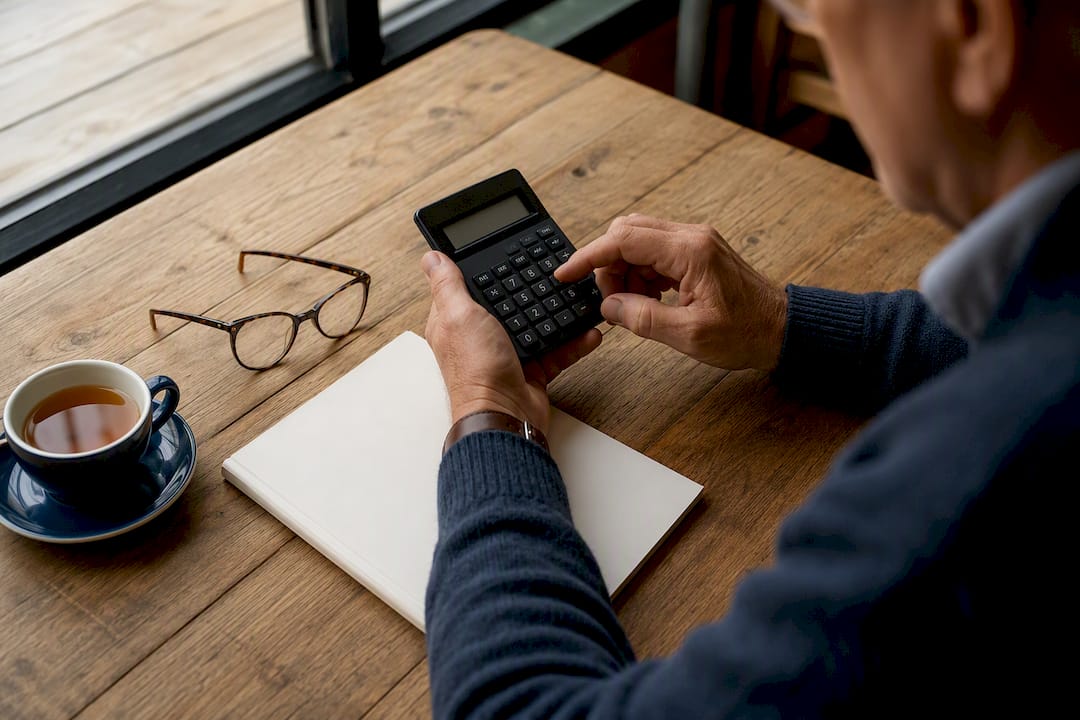 Hands using calculator to compare Medicare costs