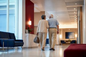 Senior couple entering a hospital corridor