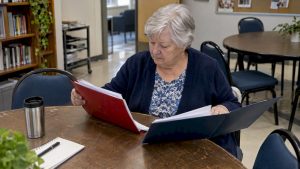 Senior comparing two insurance policy folders