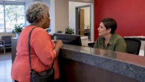 Older patient confirms plan acceptance at clinic reception