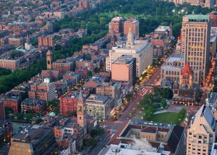 Boston city downtown aerial view with urban historical buildings at sunset.